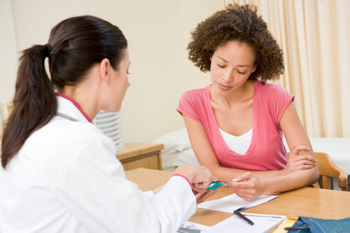 A doctor hands a HAP card to a woman