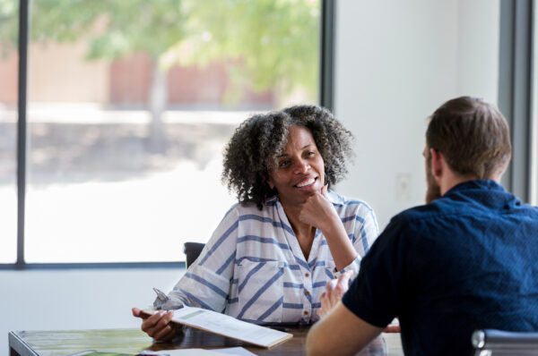 Confident mature businesswoman attentively listens during a meeting with a male associate.