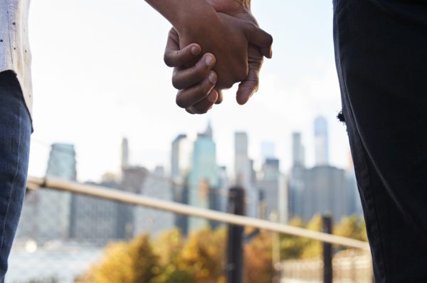 Couple holding hands with Manhattan skyline in background