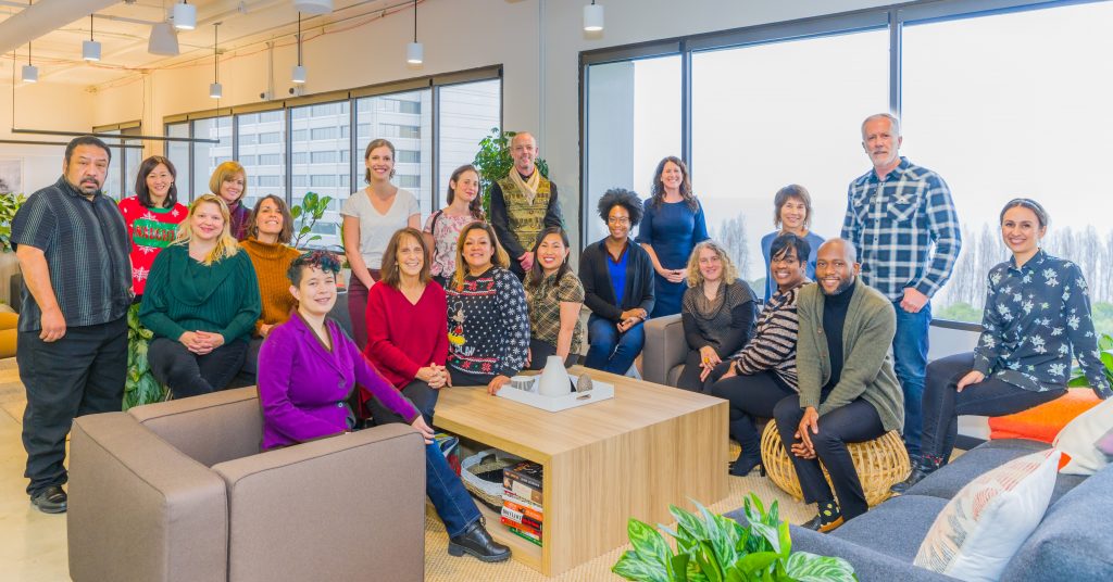 CAPTC staff sitting around a table smiling during a meeting.