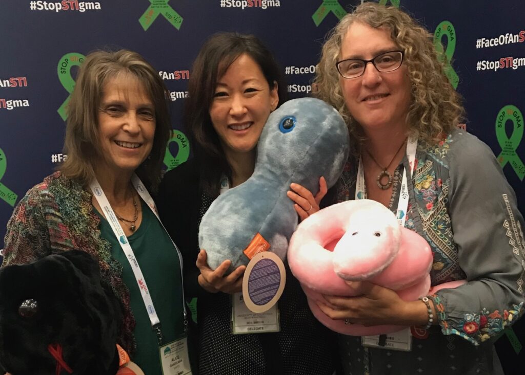 Ina, Alice, Sharon holding plush toys of viruses