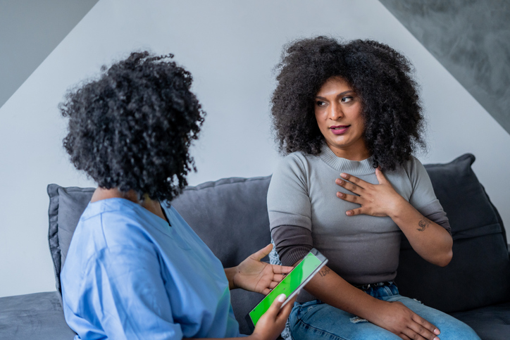 Black nurse consulting trans woman at home