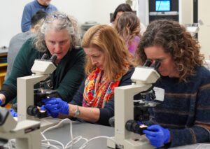 Instructor and 2 students with microscopes